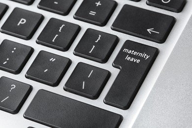 Image of Modern computer keyboard with text MATERNITY LEAVE, closeup
