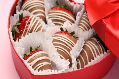 Heart shaped box with delicious chocolate covered strawberries on pink background, closeup