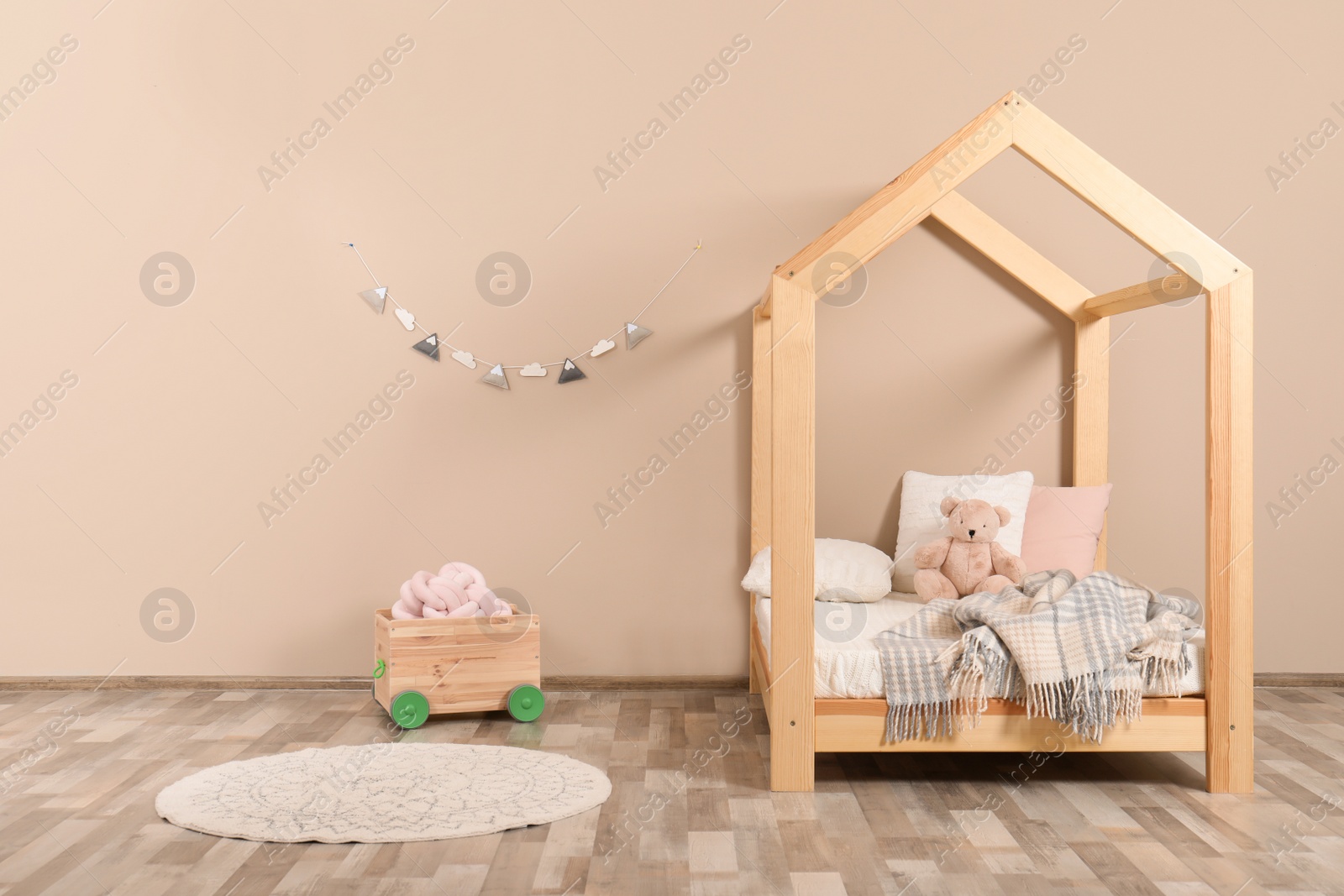 Photo of Stylish child room interior with house bed. Space for text