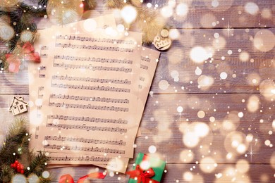 Image of Flat lay with Christmas music sheets on wooden background, space for text