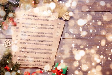 Flat lay with Christmas music sheets on wooden background, space for text