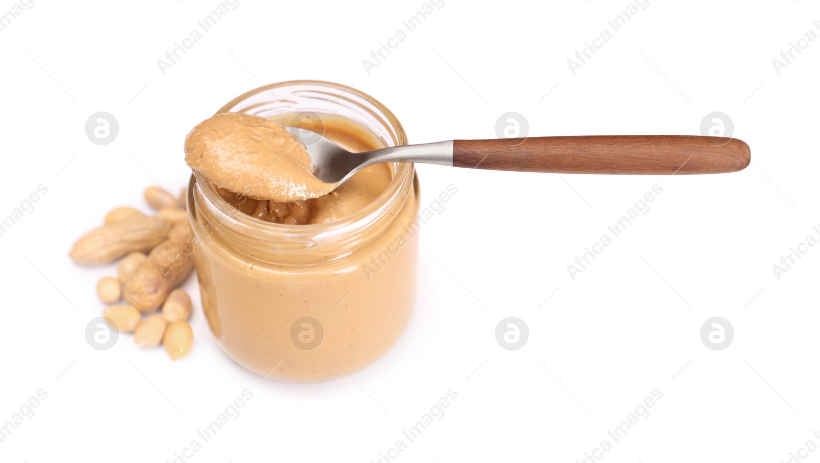 Photo of Tasty nut paste in jar, spoon and peanuts isolated on white