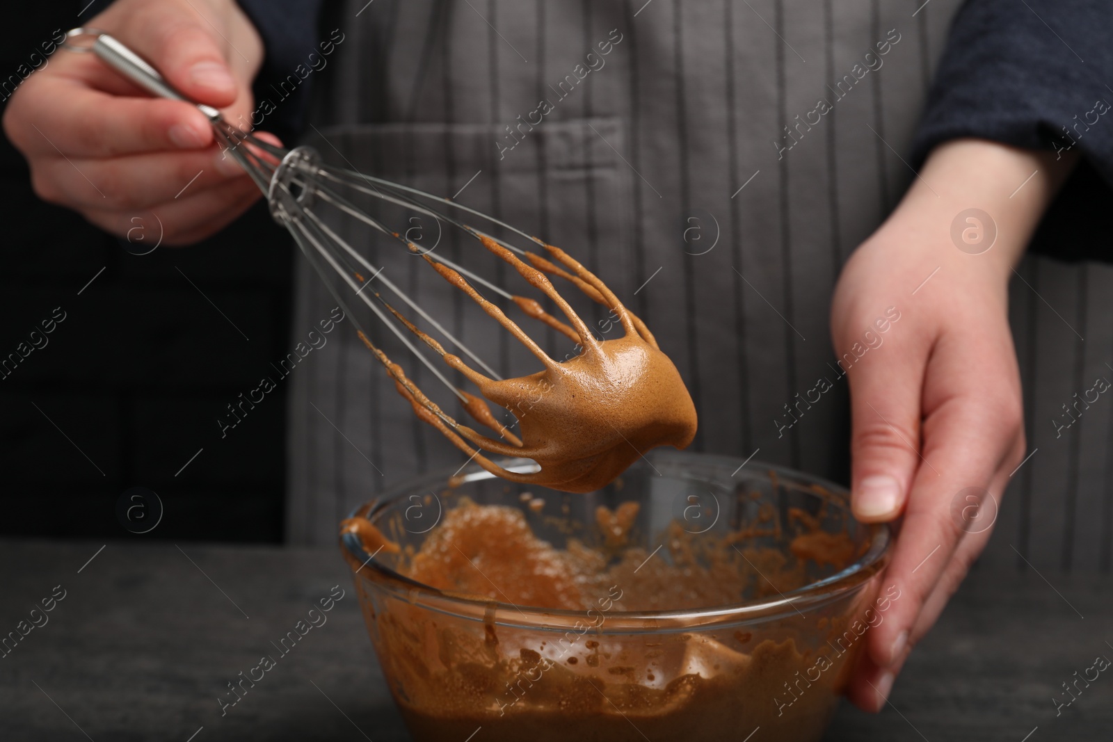 Photo of Woman whipping coffee cream at grey table, closeup