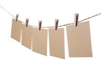 Clothespins with empty notepapers on string against white background. Space for text