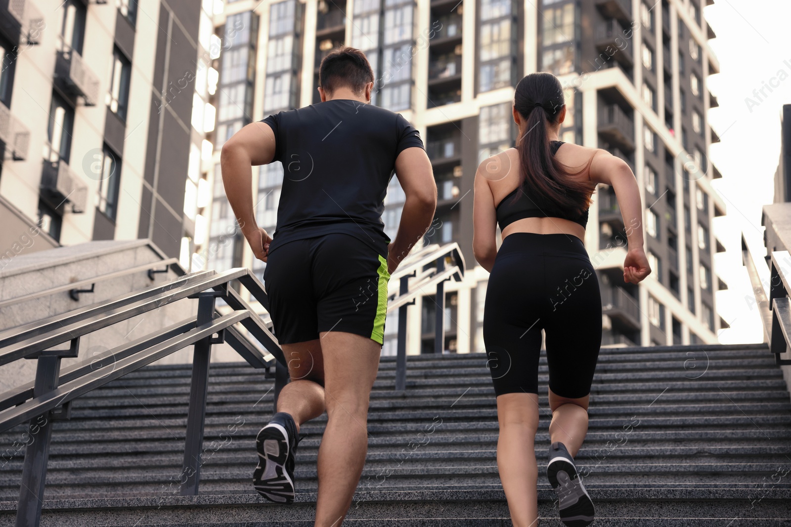 Photo of Healthy lifestyle. Couple running up steps outdoors, low angle view