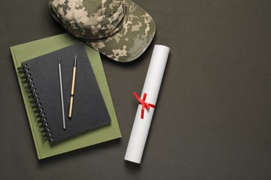 Photo of Stationery, soldier cap and diploma on dark background, flat lay with space for text. Military education