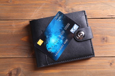 Photo of Credit card and leather wallet on wooden table, top view