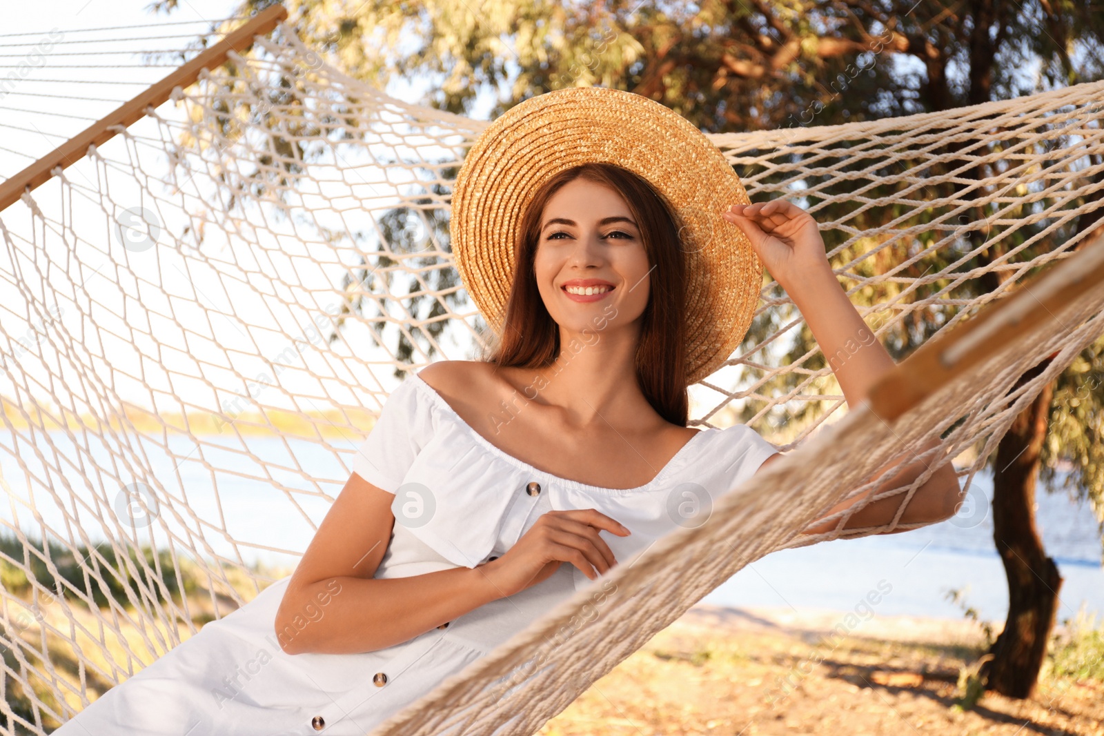 Photo of Young woman relaxing in hammock on beach. Summer vacation