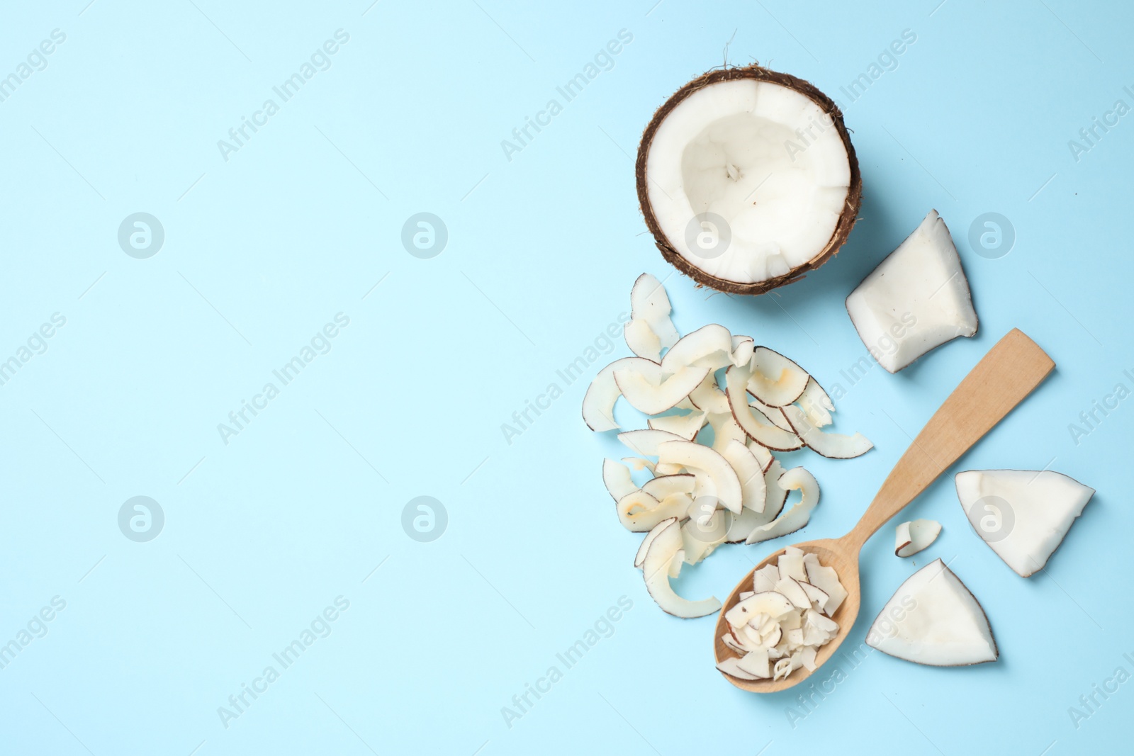 Photo of Flat lay composition with tasty coconut chips on light blue background. Space for text