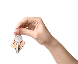 Woman holding house key with trinket on white background, closeup