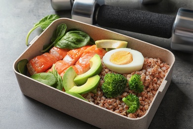 Container with natural healthy lunch on table. High protein food