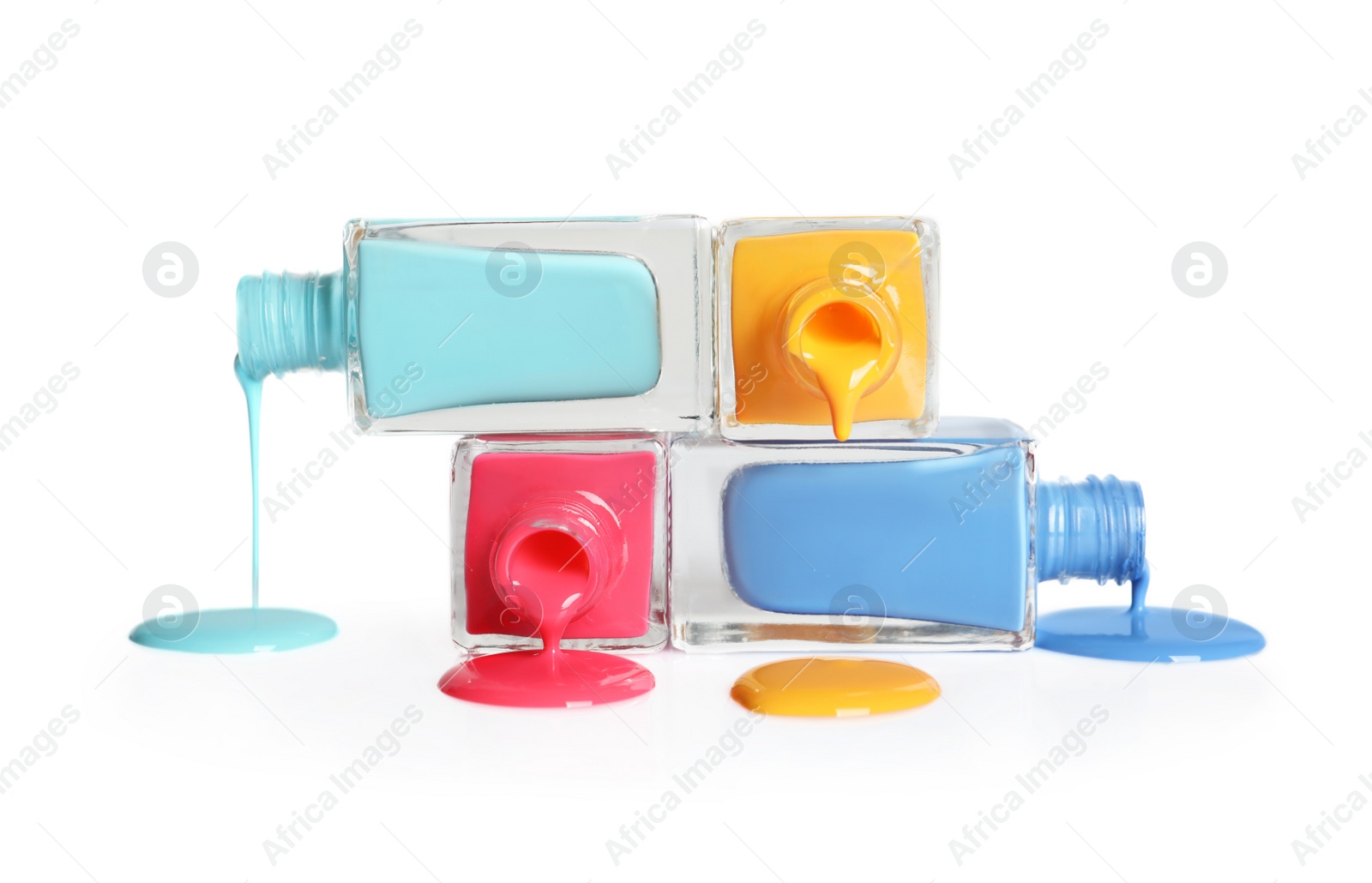 Photo of Spilled different nail polishes with bottles on white background