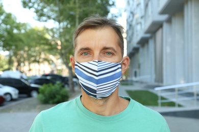 Man wearing handmade cloth mask outdoors. Personal protective equipment during COVID-19 pandemic