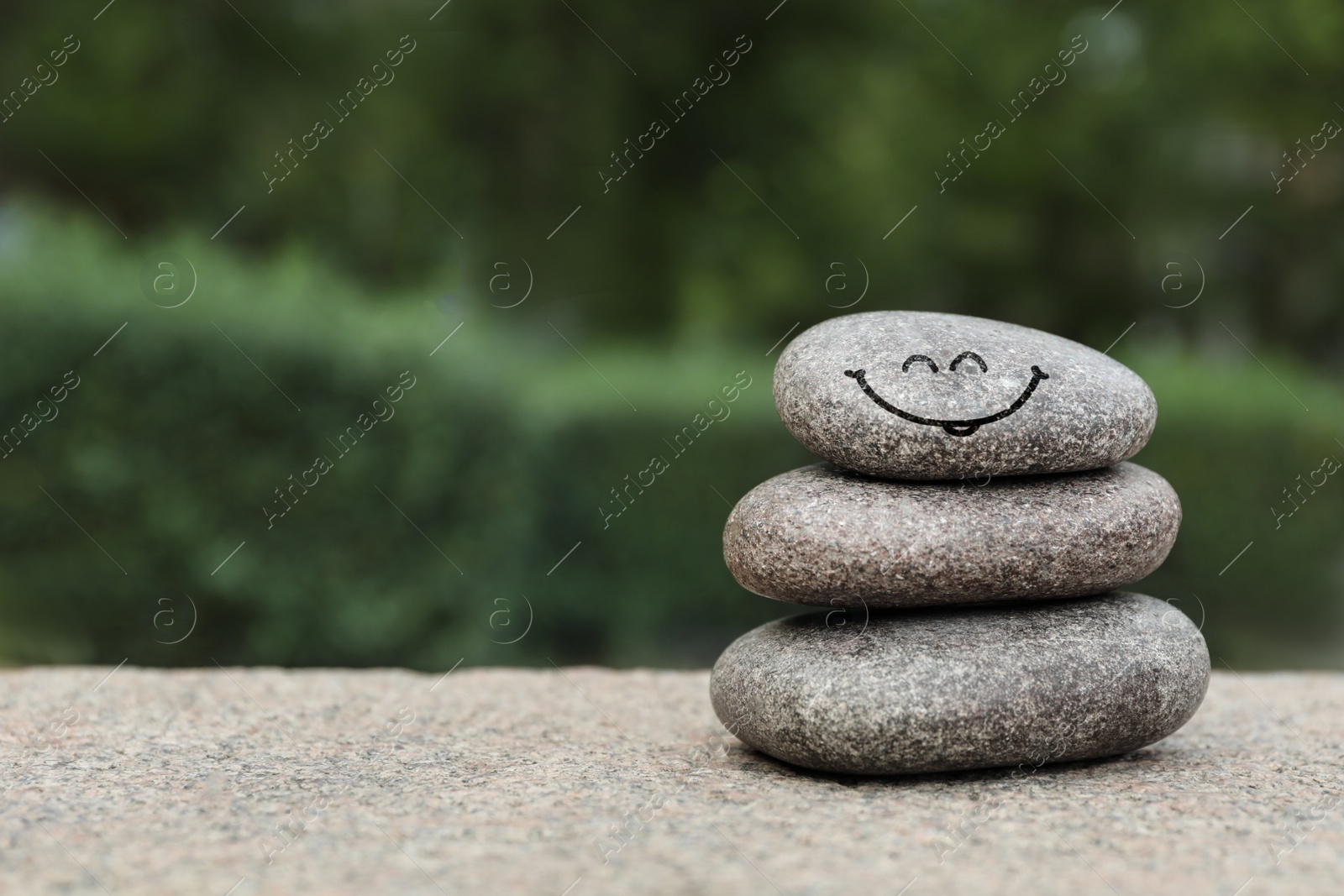 Image of Stack of stones with drawn happy face outdoors, space for text. Be in harmony and enjoying your life