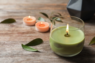 Photo of Beautiful composition with burning wax candle on wooden table