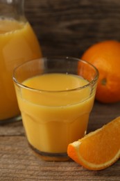 Photo of Tasty fresh oranges and juice on wooden table, closeup