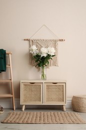 Room interior with wooden chest of drawers near beige wall