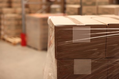 Photo of Boxes wrapped in stretch film at warehouse, closeup. Space for text