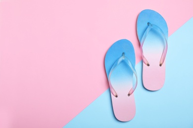 Photo of Stylish beach flip-flops on color background, top view