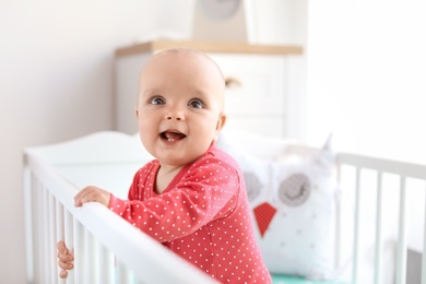 Cute baby girl in crib at home