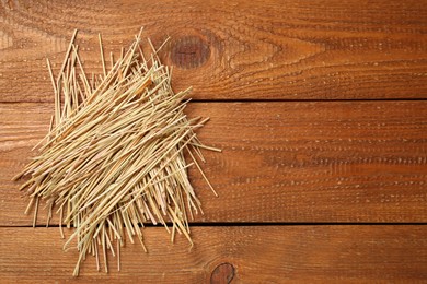 Dried hay on wooden background, top view. Space for text