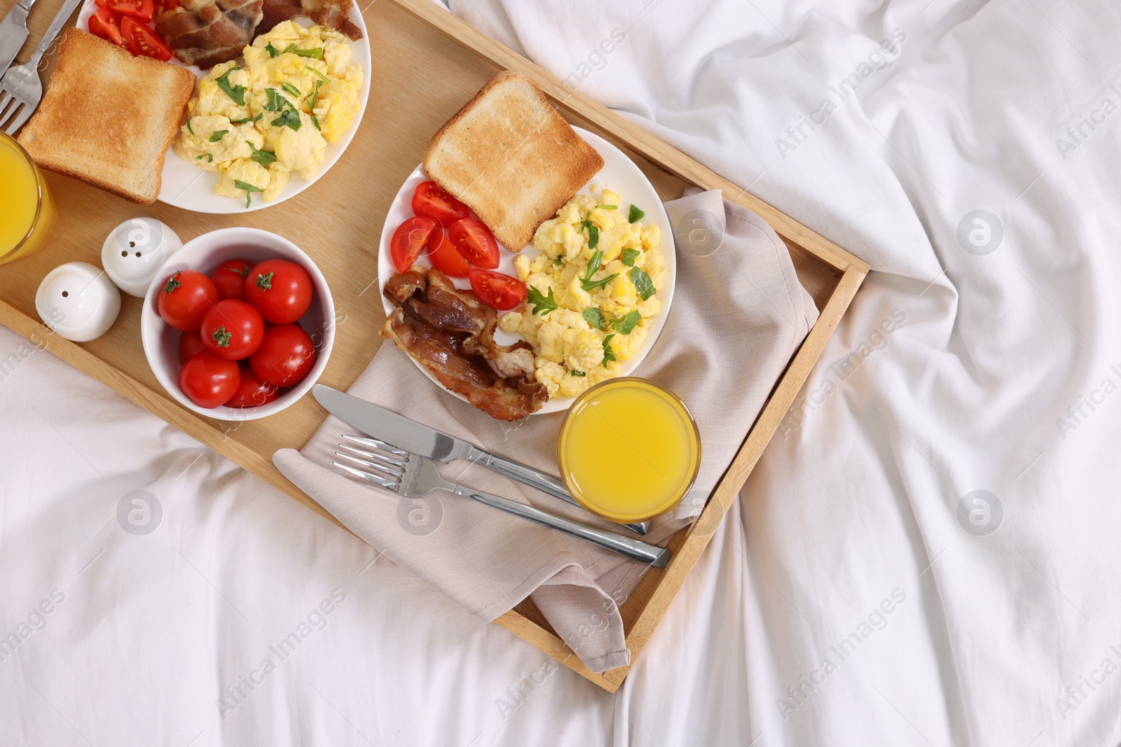 Good morning. Tray with tasty breakfast on bed, top view Photo of Good morning. Tray with tasty breakfast on bed, top view