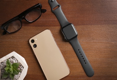Photo of Flat lay composition with stylish smart watch on wooden table
