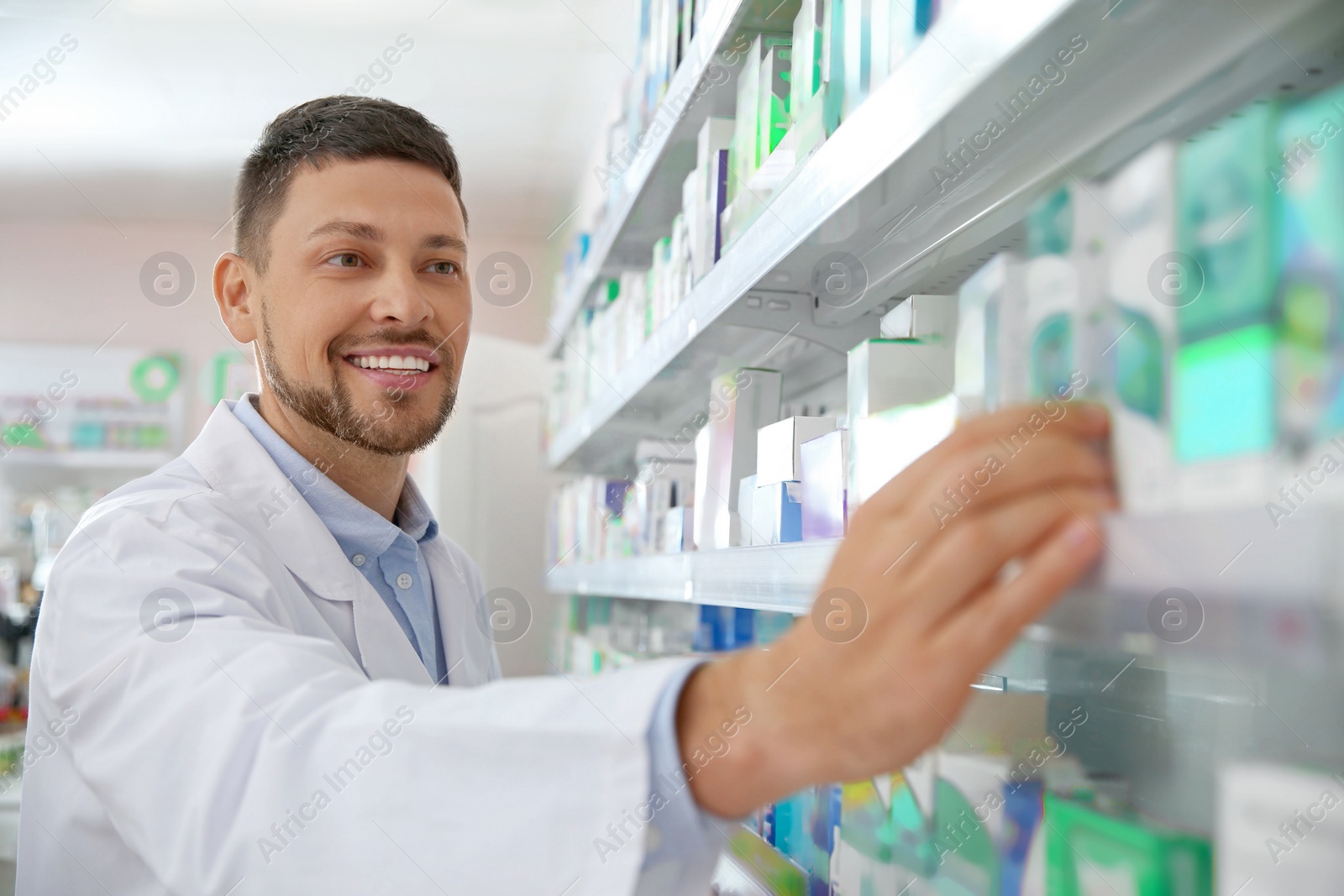 Photo of Professional pharmacist near shelves with merchandise in drugstore