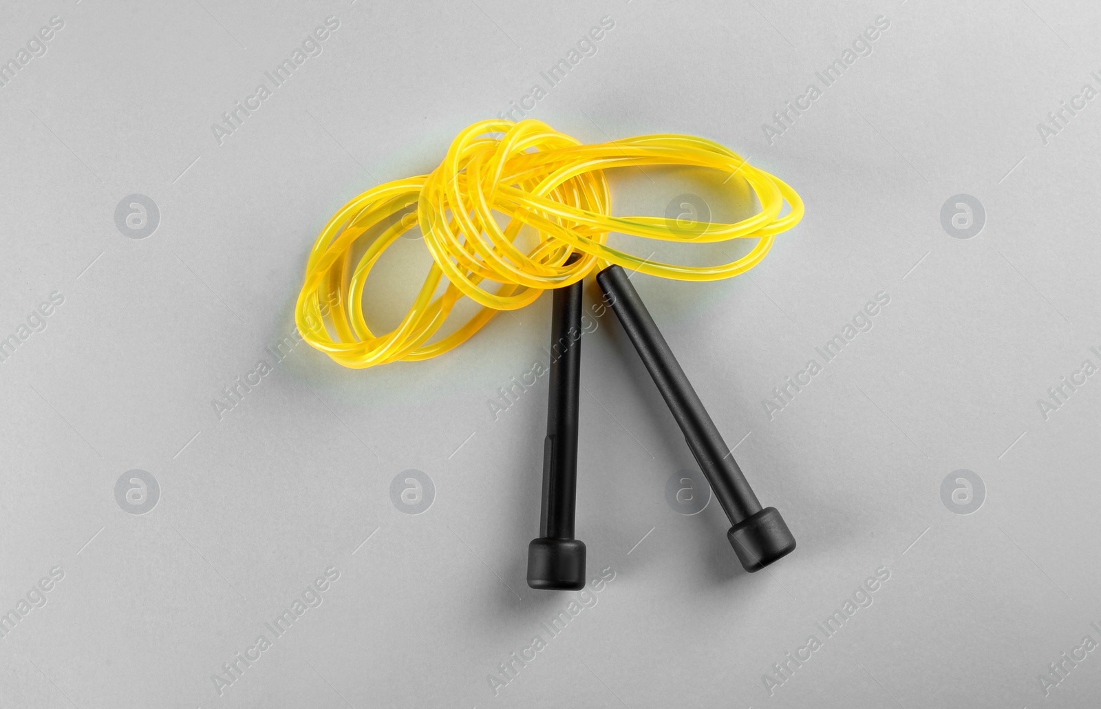 Photo of Skipping rope on light grey background, top view. Sports equipment