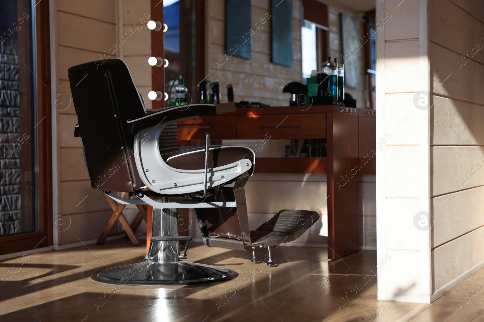 Photo of Stylish hairdresser's workplace with professional armchair in barbershop