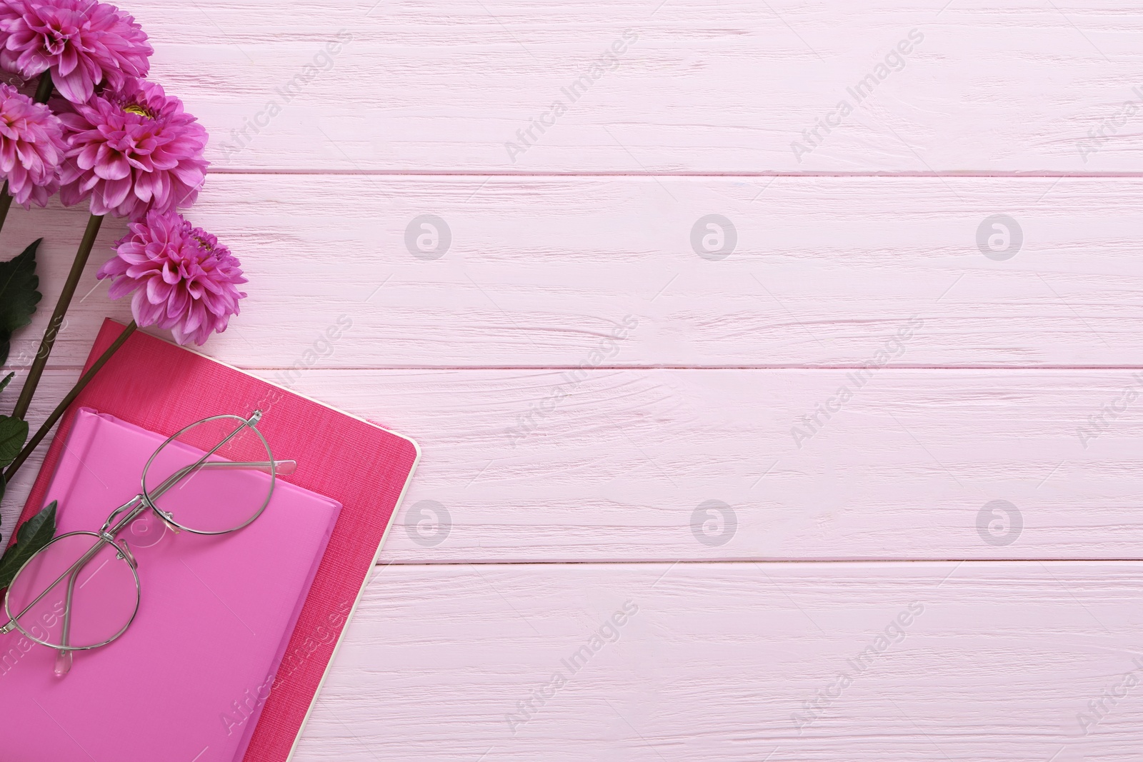 Photo of Beautiful flowers and stationery on pink wooden background, flat lay with space for text. Teacher's Day