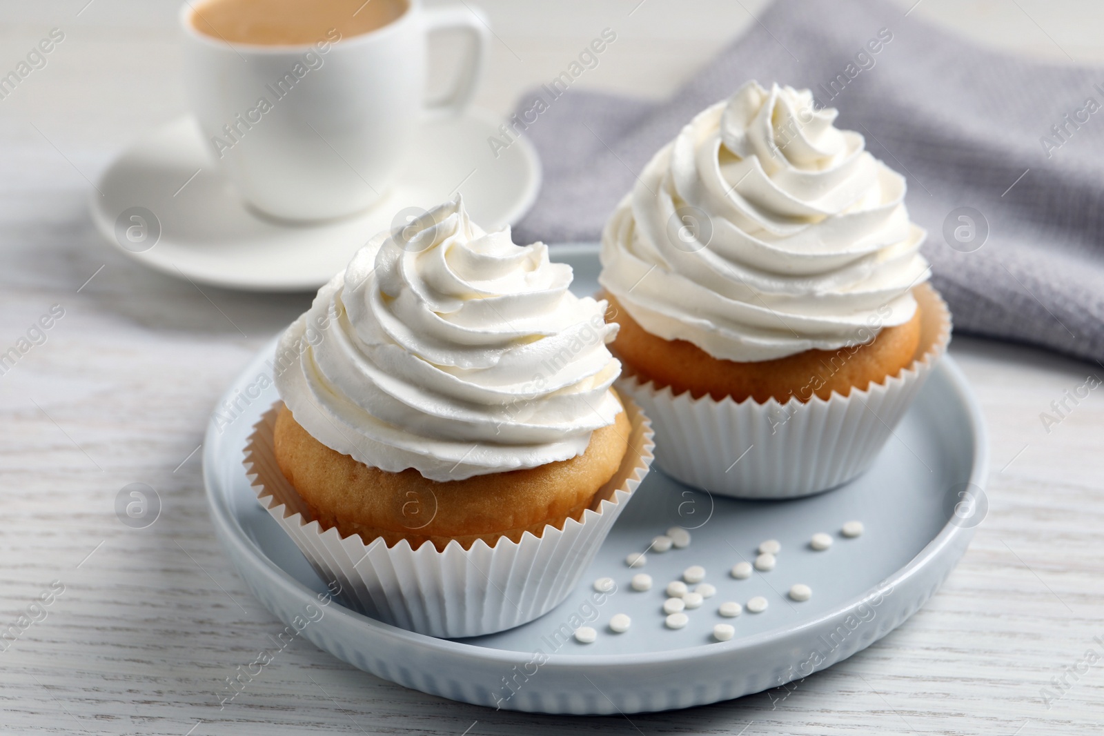 Photo of Delicious cupcakes with cream on white wooden table, closeup