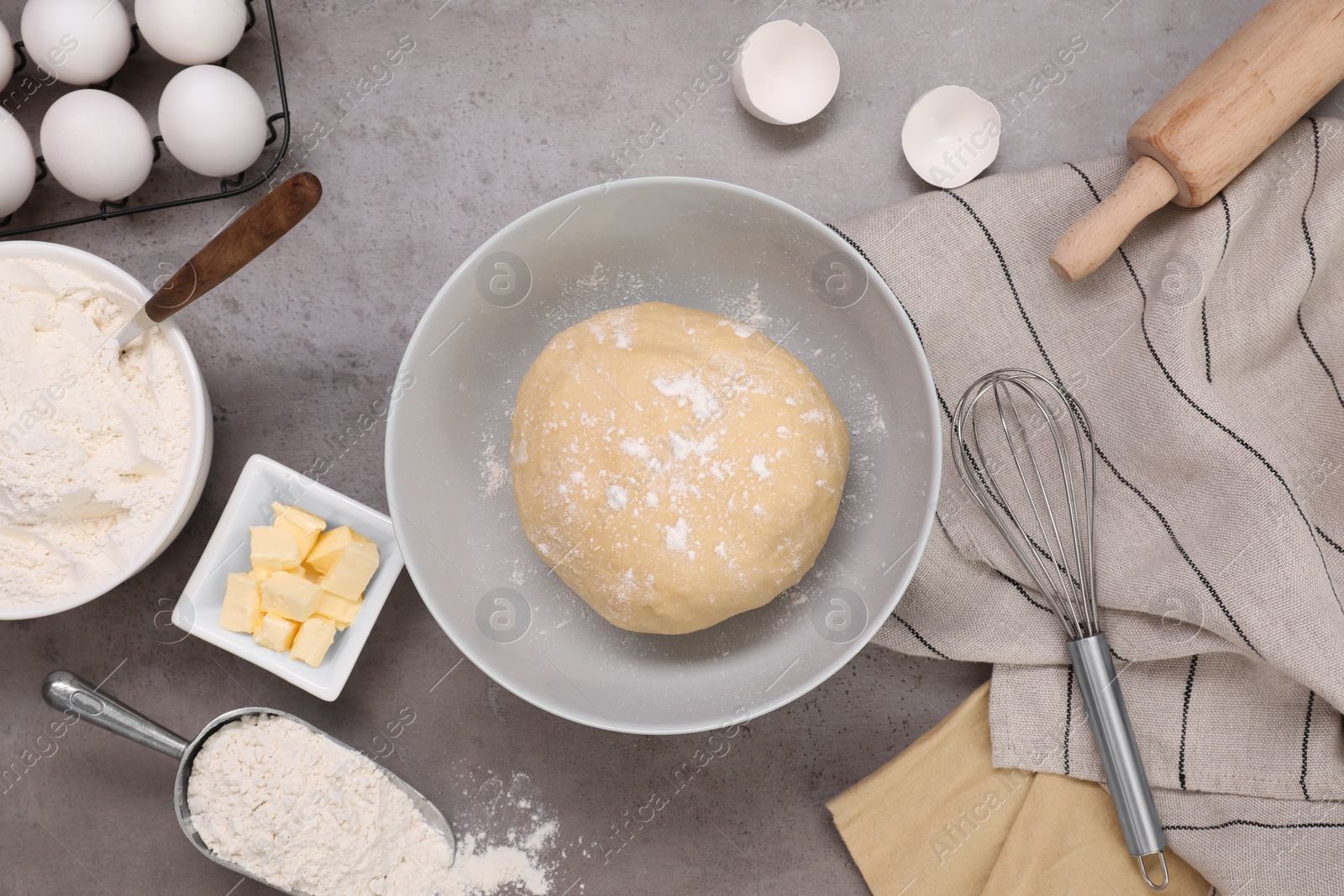 Photo of Fresh dough and different ingredients for making baklava on grey table, flat lay