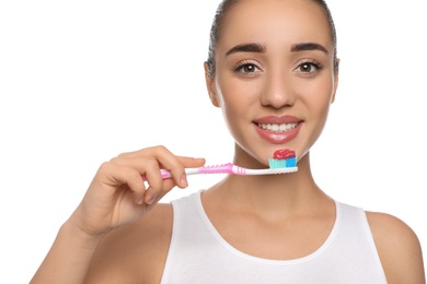 Woman holding toothbrush with paste on white background