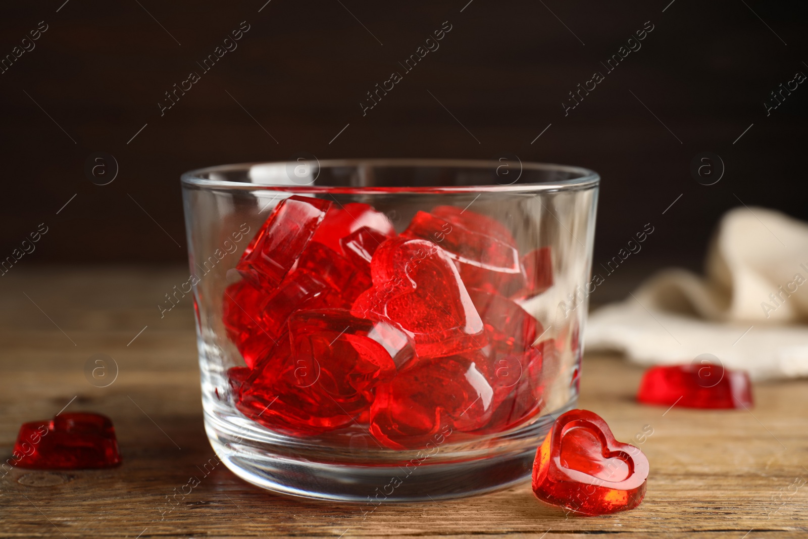 Photo of Sweet heart shaped jelly candies on wooden table, closeup