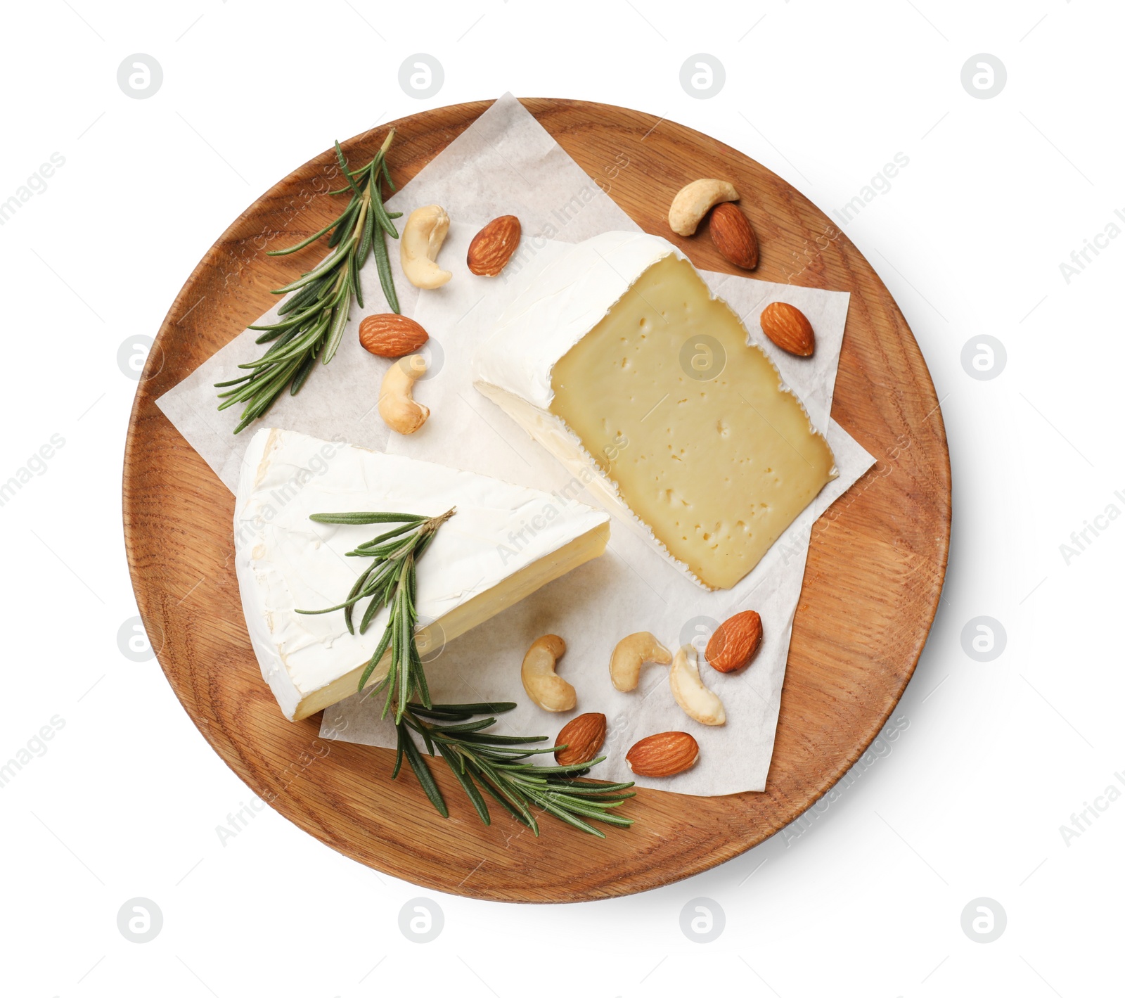 Photo of Plate with pieces of tasty camembert cheese, nuts and rosemary isolated on white, top view