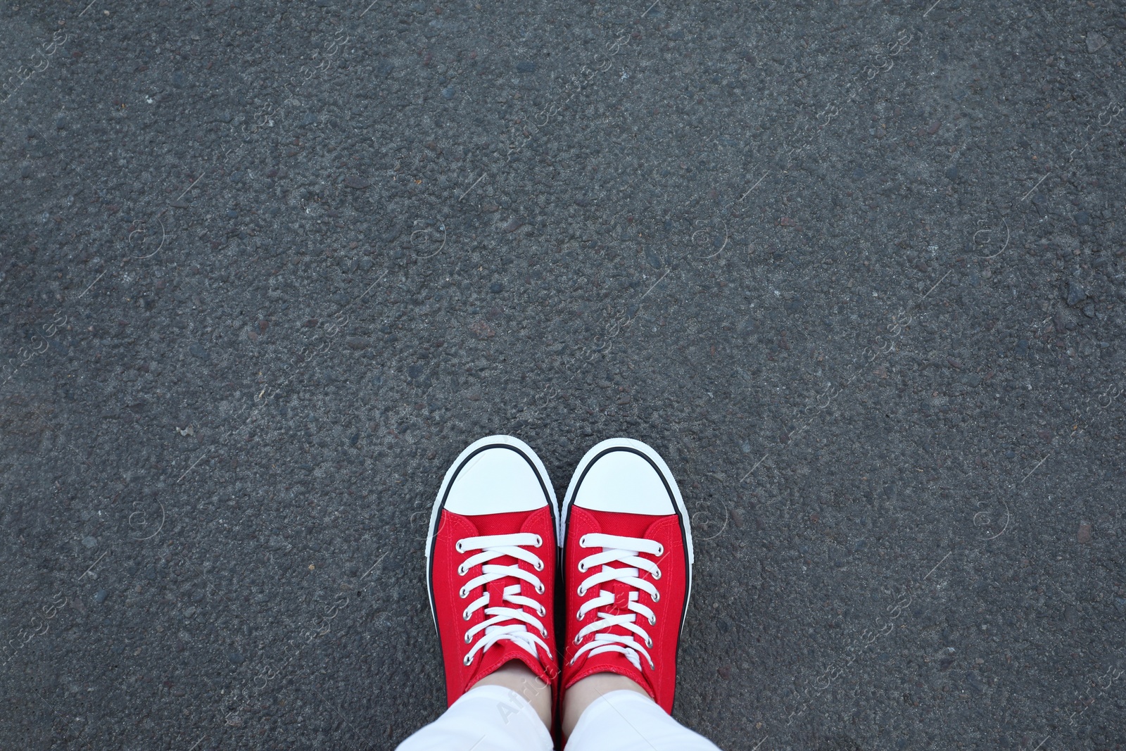 Photo of Woman standing on asphalt, top view. Space for text