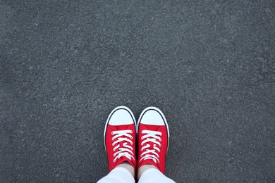 Photo of Woman standing on asphalt, top view. Space for text