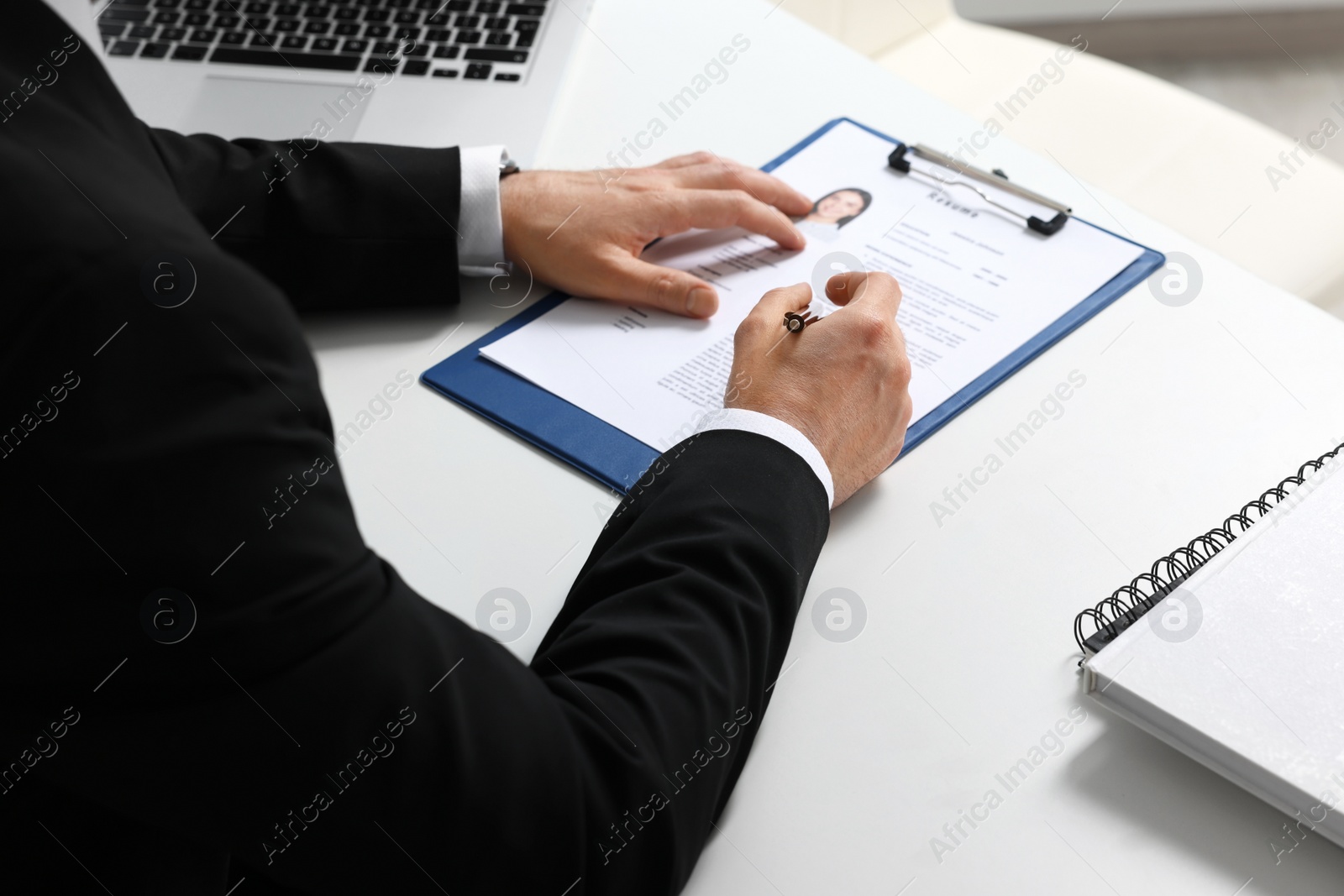 Photo of Human resources manager reading applicant's resume at table, closeup