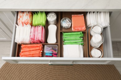 Photo of Storage of different feminine hygiene products in drawer indoors, top view
