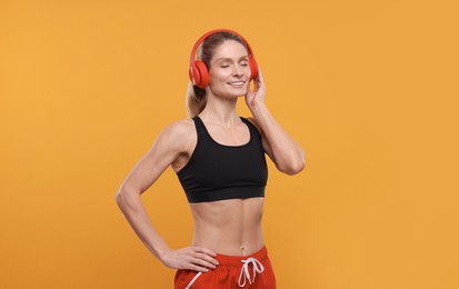 Photo of Sportswoman with red headphones on yellow background