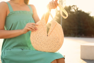 Young woman with stylish straw bag outdoors, closeup