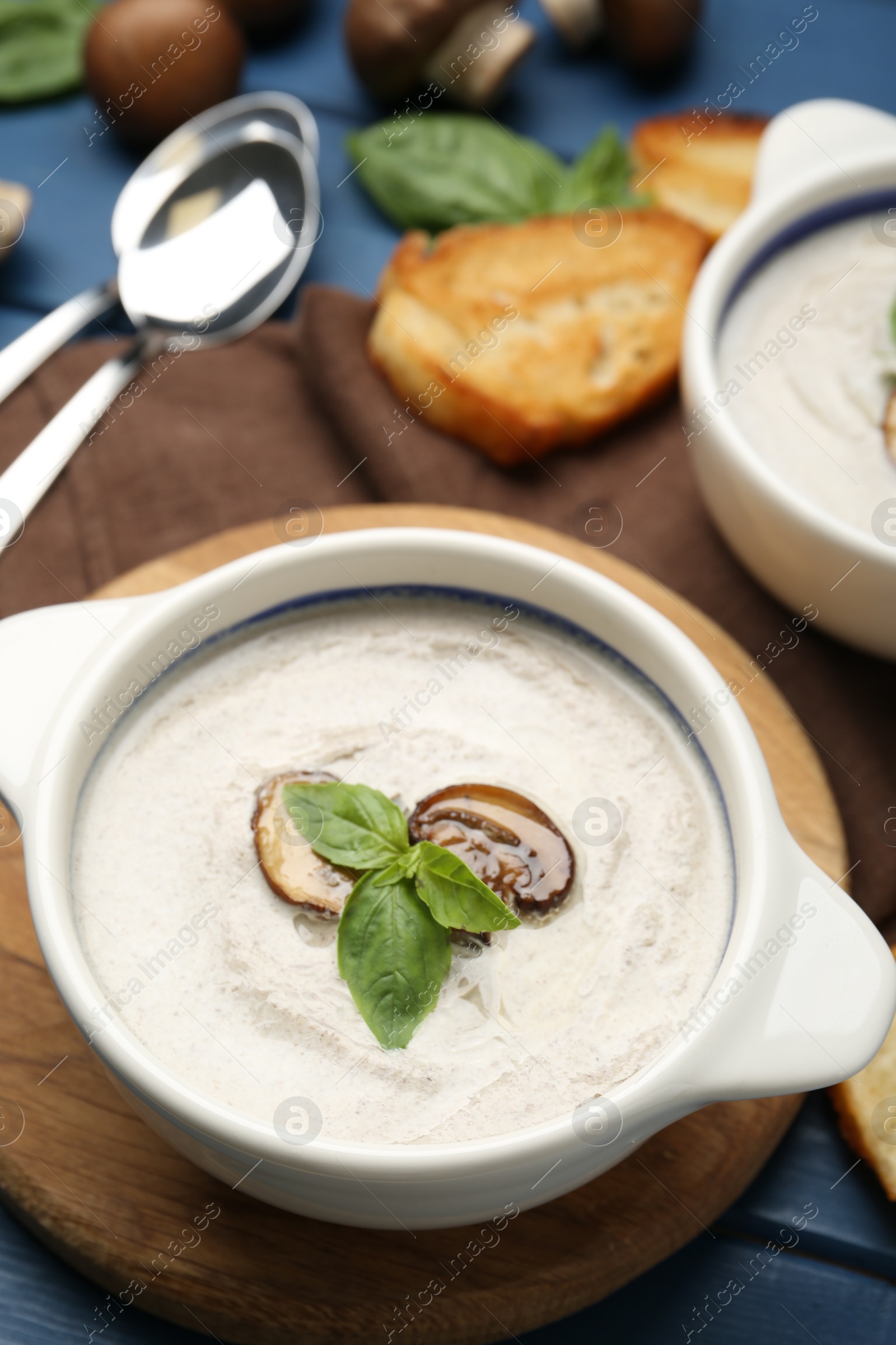 Photo of Fresh homemade mushroom soup served on blue wooden table