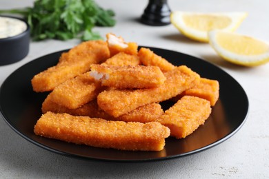 Photo of Fresh breaded fish fingers served on white table