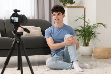 Smiling teenage blogger sitting and streaming at home