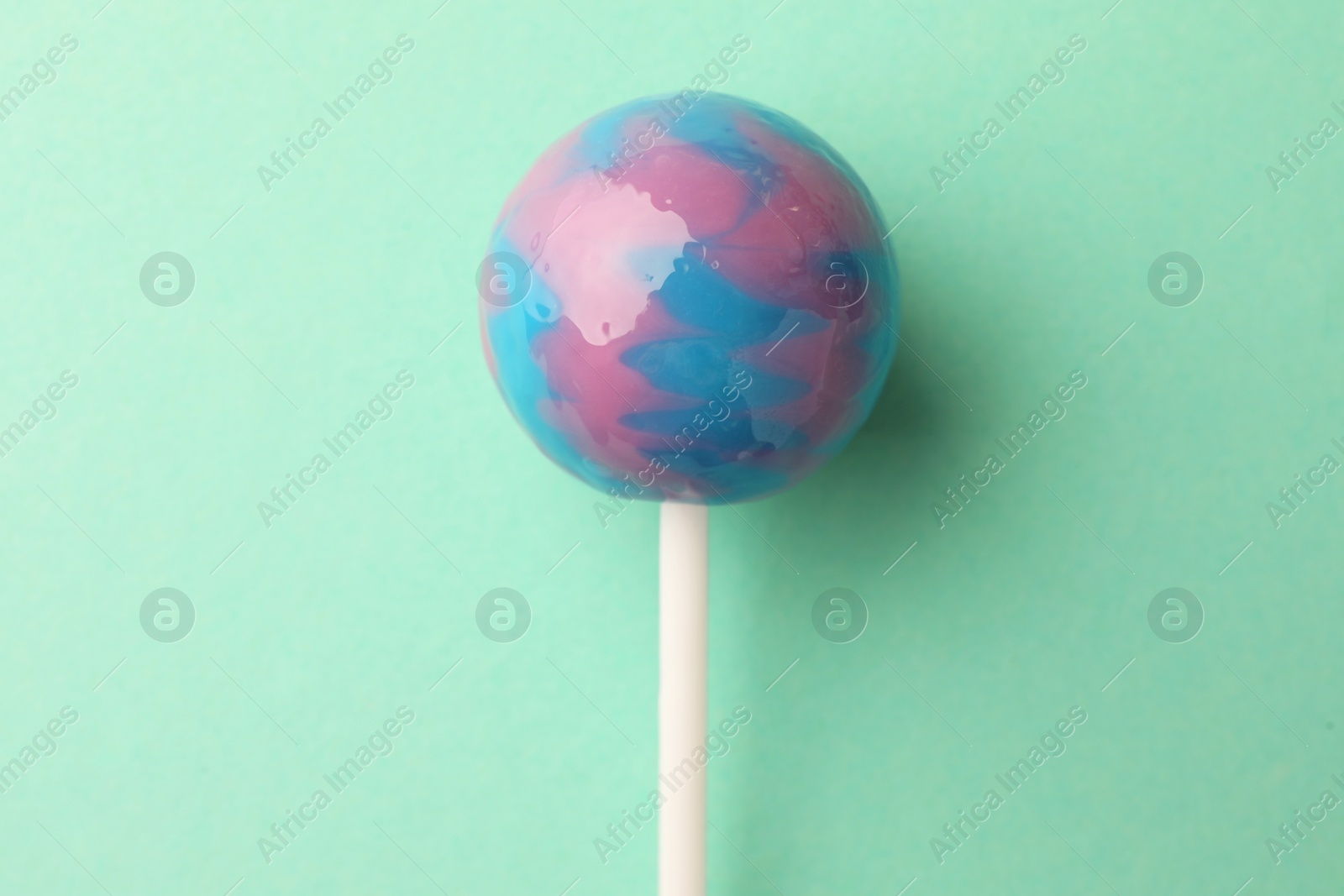 Photo of Tasty lollipop on turquoise background, top view