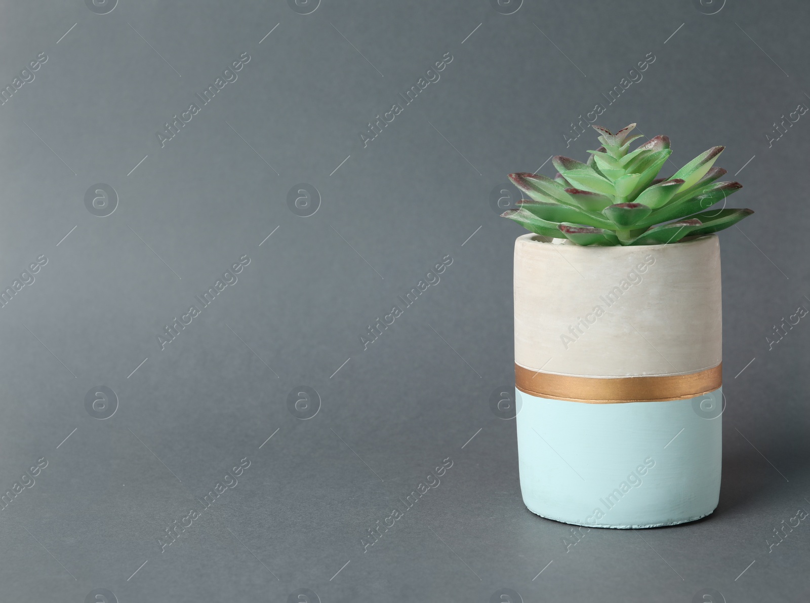 Photo of Beautiful artificial plant in flower pot on grey background, space for text