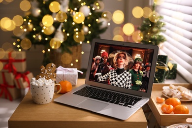 MYKOLAIV, UKRAINE - DECEMBER 25, 2020: Laptop displaying The Witches movie on table at home. Cozy winter holidays atmosphere