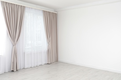 Photo of Window with elegant curtains in empty room. Space for text