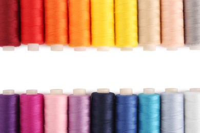 Photo of Frame of colorful sewing threads on white background, flat lay. Space for text